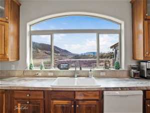 Kitchen with plenty of natural light, white dishwasher, a mountain view, and sink
