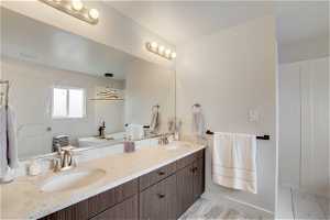 Bathroom with oversized vanity, wood-type flooring, and dual sinks