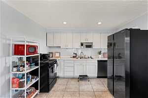 Kitchen featuring sink, light tile floors, ornamental molding, backsplash, and stainless steel appliances