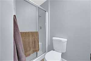 Bathroom with toilet and a shower with shower door