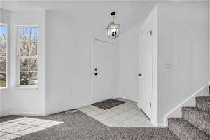 Entrance foyer featuring light colored carpet and a wealth of natural light