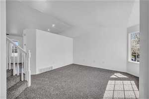 Spare room with light carpet and vaulted ceiling