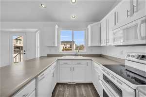 Kitchen featuring white cabinets, white appliances, sink, and dark hardwood / wood-style flooring