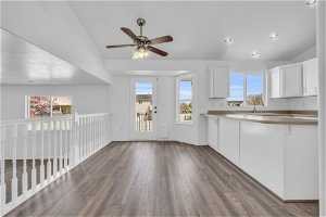 Kitchen with ceiling fan, white cabinetry, dark hardwood / wood-style floors, and a healthy amount of sunlight