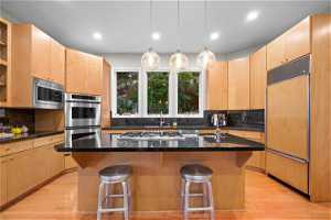 MAIN LEVEL KITCHEN WITH STAINLESS STEEL APPLIANCES AND DOUBLE OVENS.