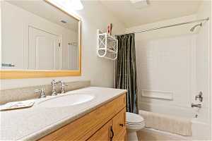Full bathroom featuring vanity, tile flooring, shower / bath combo, and toilet