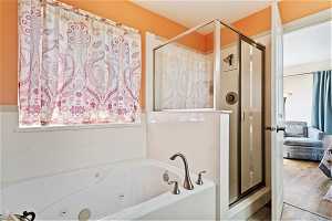 Bathroom featuring shower with separate bathtub and hardwood / wood-style floors