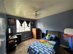 Bedroom featuring ceiling fan, a textured ceiling, and light colored carpet