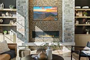 Living room featuring tile flooring and a stone fireplace