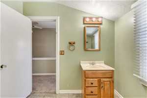 Bathroom featuring vanity, ceiling fan, tile floors, and lofted ceiling