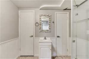 Bathroom with walk in shower, a textured ceiling, and vanity