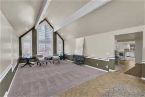 Sitting room featuring high vaulted ceiling, beamed ceiling, and light colored carpet
