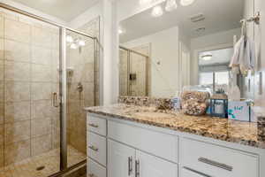 Bathroom with walk in shower and vanity with extensive cabinet space