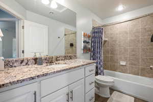 Full bathroom featuring toilet, shower / tub combo, and vanity