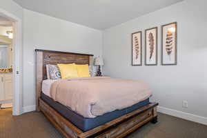 Bedroom featuring dark carpet and connected bathroom