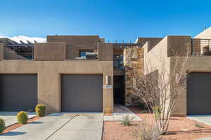 Pueblo revival-style home featuring a balcony and a garage