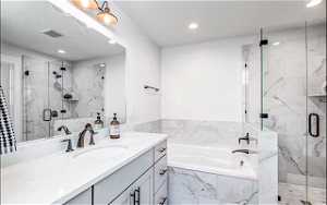 Bathroom featuring separate shower and tub and vanity with extensive cabinet space