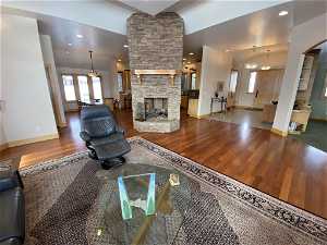 Living room featuring dark hardwood / wood-style floors and a stone fireplace