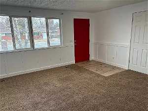 Living/family room, front entry, new carpet, wainscoting, textured ceiling, natural light