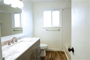 Full bathroom featuring shower / bathing tub combination, toilet, vanity, and a healthy amount of sunlight