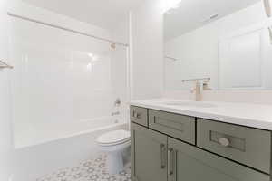 Full bathroom with bathing tub / shower combination, toilet, tile patterned flooring, and vanity