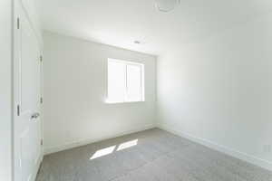 Unfurnished bedroom with light carpet