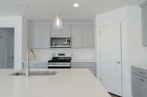 Kitchen with sink, gray cabinetry, and appliances with stainless steel finishes