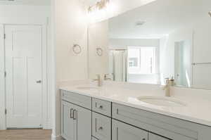 Bathroom featuring an enclosed shower, vanity, and hardwood / wood-style floors