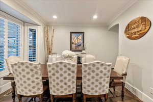 Dining area with engineered hardwood flooring and ornamental molding