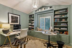 Office area featuring built in features, a notable chandelier, and lofted ceiling