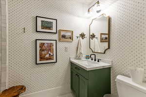 Bathroom featuring toilet and vanity with extensive cabinet space