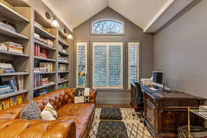 Office space with lofted ceiling, a textured ceiling, and engineered hardwood flooring