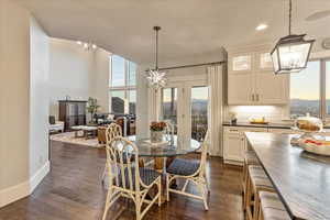 Dining room with french doors, a notable chandelier, and engineered hardwood flooring