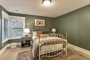 Carpeted bedroom featuring a textured ceiling