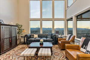 Living room with a high ceiling, a healthy amount of sunlight, and engineered hardwood flooring