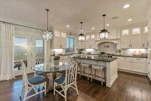 Dining area with engineered hardwood flooring, sink, and ornamental molding