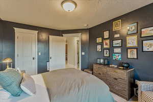 Carpeted bedroom featuring a textured ceiling