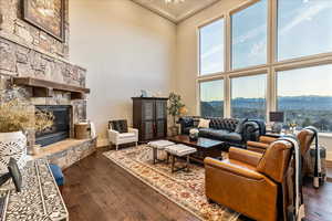 Living room featuring a fireplace, engineered hardwood flooring, a mountain view, and a towering ceiling