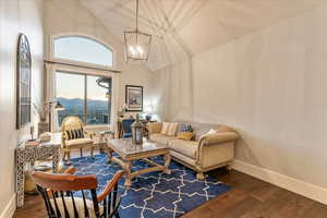 Living room with a mountain view, high vaulted ceiling, an inviting chandelier, and engineered hardwood flooring