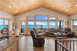 Living room with a water view, wood ceiling, dark LVP floors, and a wealth of natural light