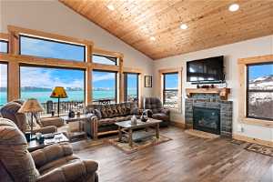 Living room with dark LVP flooring, a water view, plenty of natural light, and a fireplace