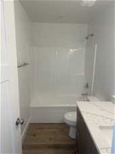Full bathroom with vanity, toilet, tub / shower combination, and hardwood / wood-style flooring