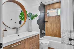 Full bathroom with toilet, shower / tub combo, vanity, and wood-type flooring