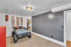 Bedroom with a textured ceiling and light carpet