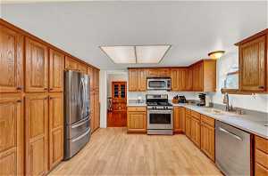 Kitchen with sink, stainless steel appliances, and light hardwood / wood-style flooring