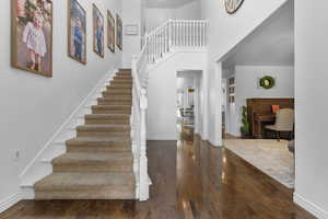 Foyer entrance with a towering ceiling and dark hardwood / wood-style flooring