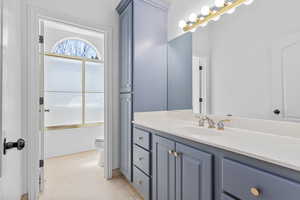 Full bathroom with tile flooring, bath / shower combo with glass door, toilet, and oversized vanity