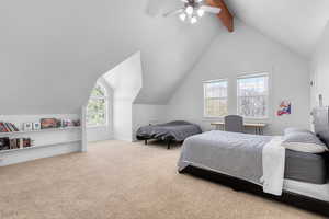 Carpeted bedroom featuring ceiling fan and lofted ceiling with beams