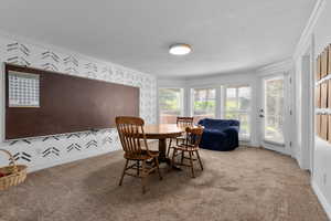 Carpeted dining room with ornamental molding