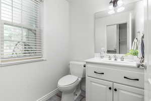 Bathroom featuring toilet, large vanity, and tile floors